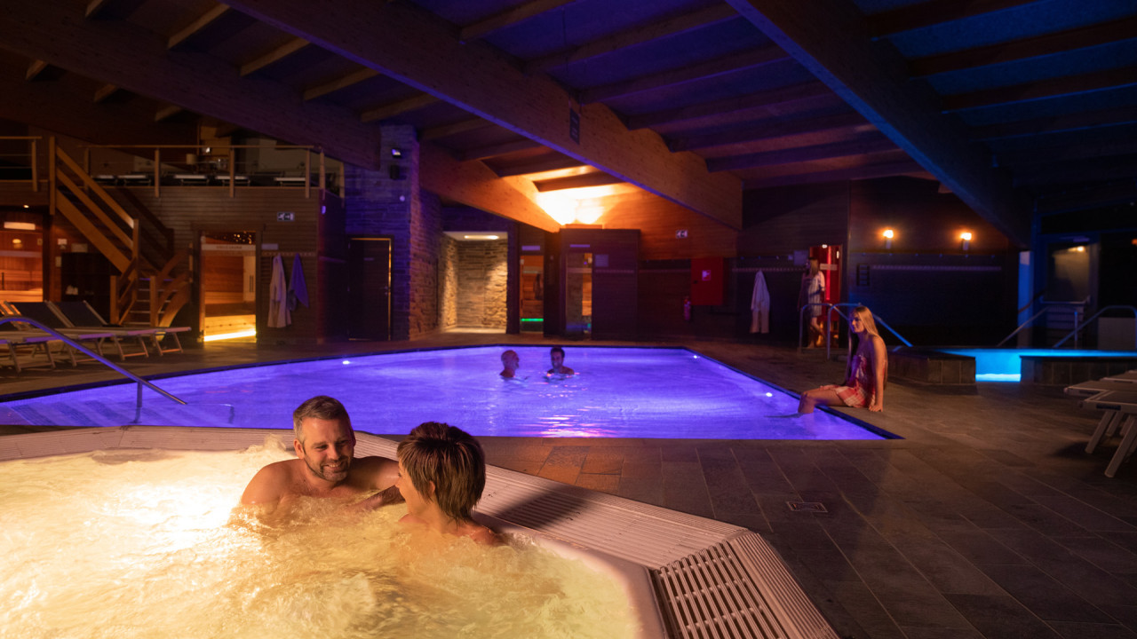 Man en vrouw in het donker in een bubbelbad binnen