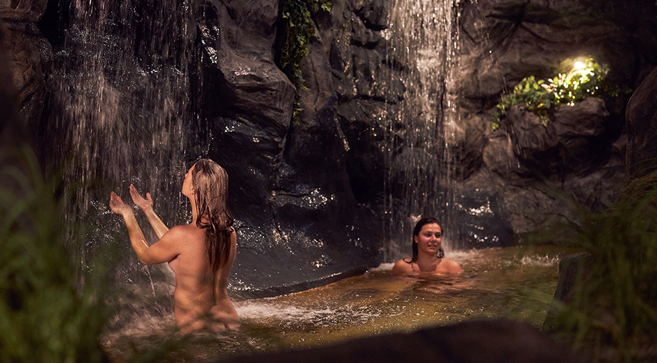 Vrouw heeft handen in het water van de waterval