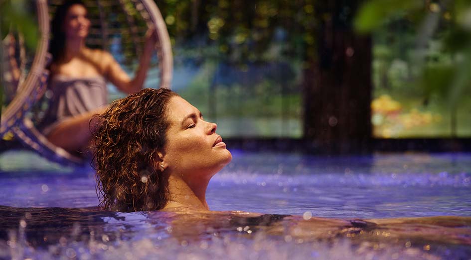 Vrouw geniet van warm water in zwembad