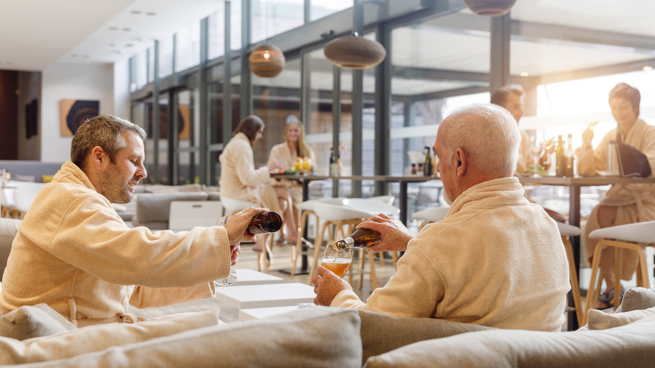 Twee mannen proosten met een biertje in restaurant