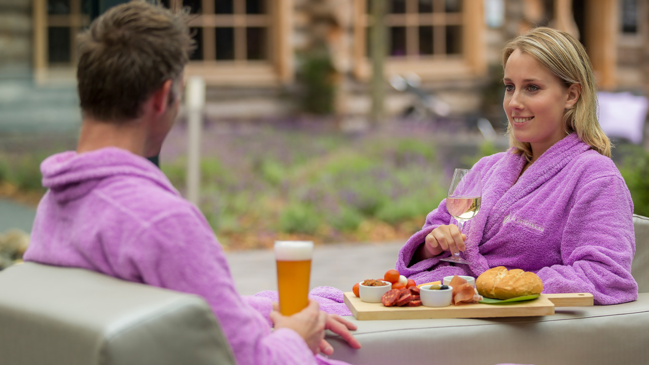 Man en vrouw eten en drinken in serre van SpaPuur