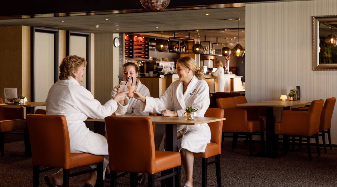 Drie vrouwen in het restaurant van SpaWell met een smoothie