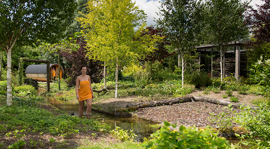 Vrouw loopt door Kneip voetenpad in kuurtuin van Veluwse Bron