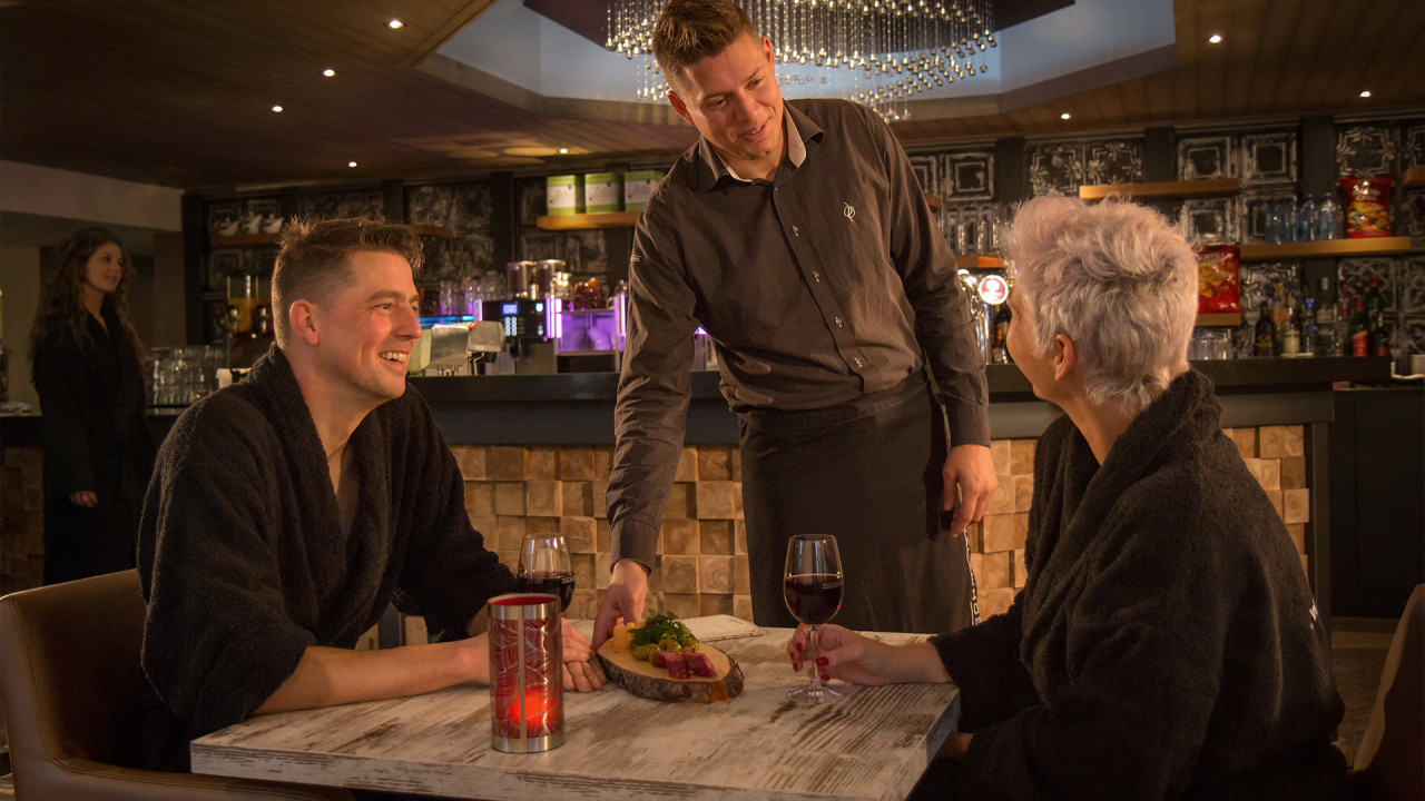 Man en vrouw genieten van een wijntje en borrelplank 